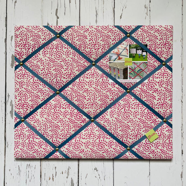 Patterned memo board with decorative items on a wooden surface